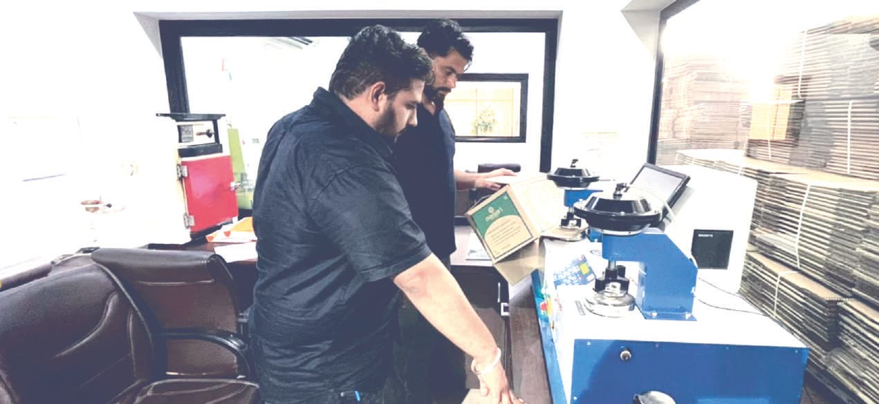 Conducting a bursting strength test in the R&D lab at Sampuran Packaging